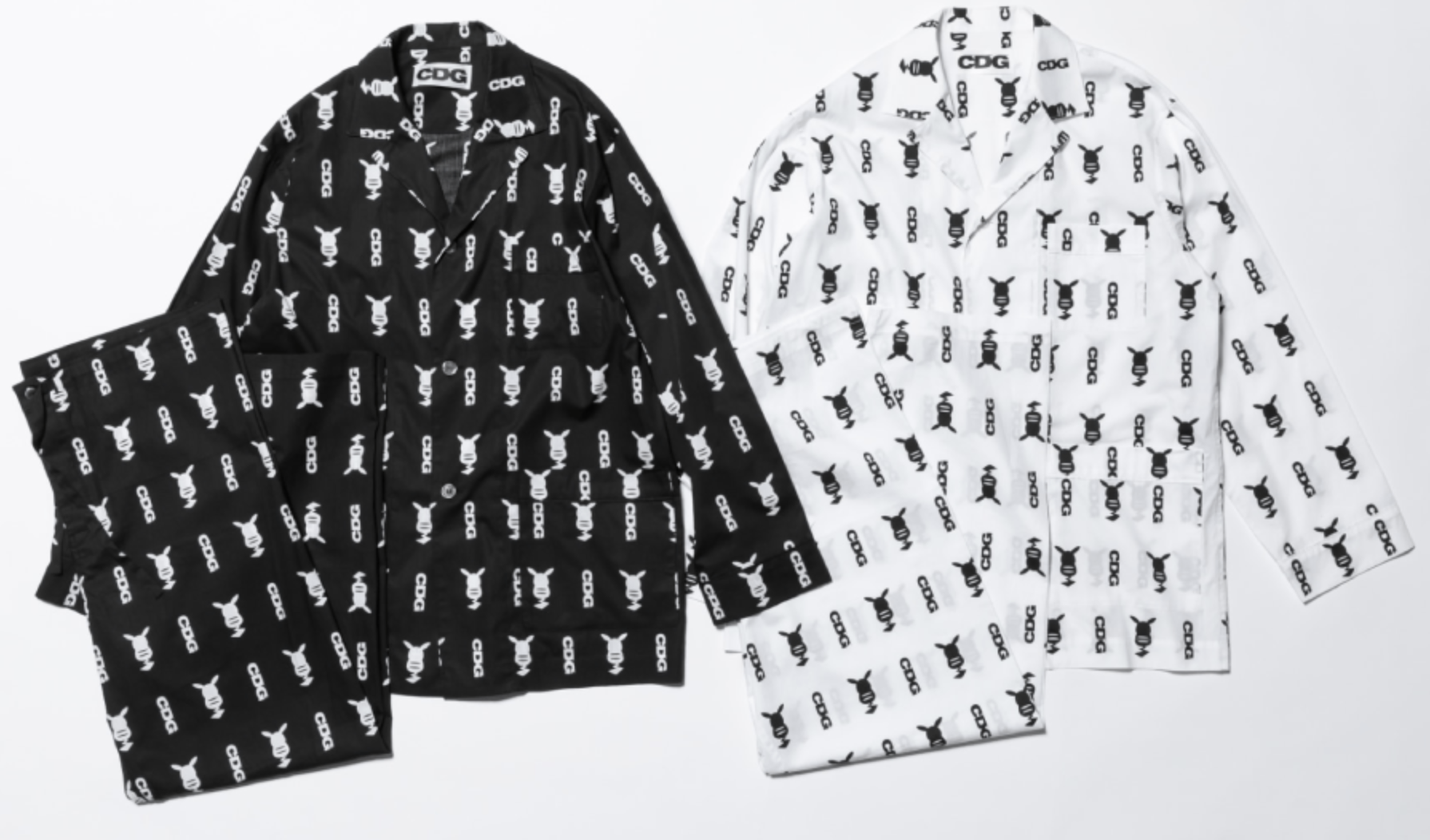 Pajama (?) set of a camp collar shirt with matching pants. One is black and one is white. Both have a contrasting pattern of Pikachu from above and the CDG logo vertically