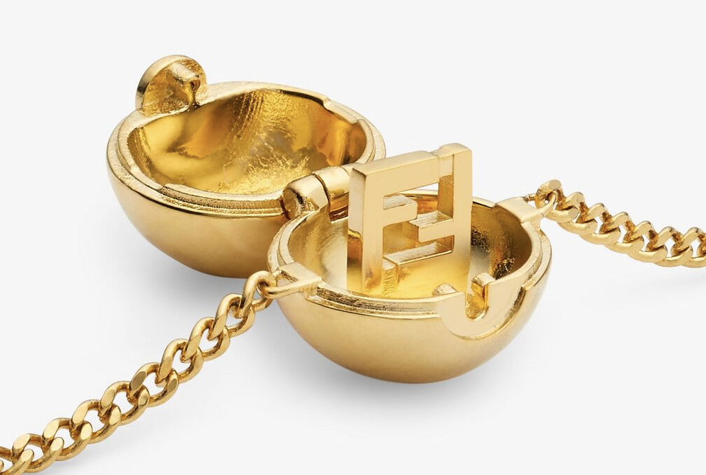 Gold charm of opened Pokeball with Fendi logo